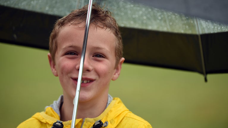 Boy holding an umbrella in the garden